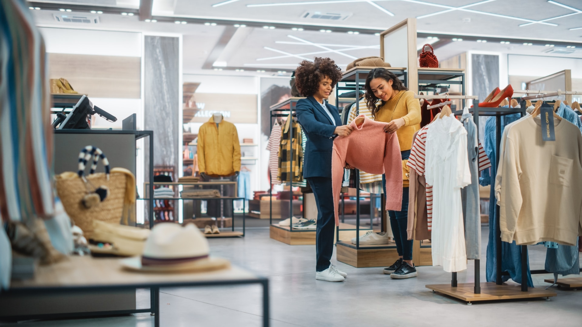 two women shopping in a clothing store while surrounded by racks of stylish clothes